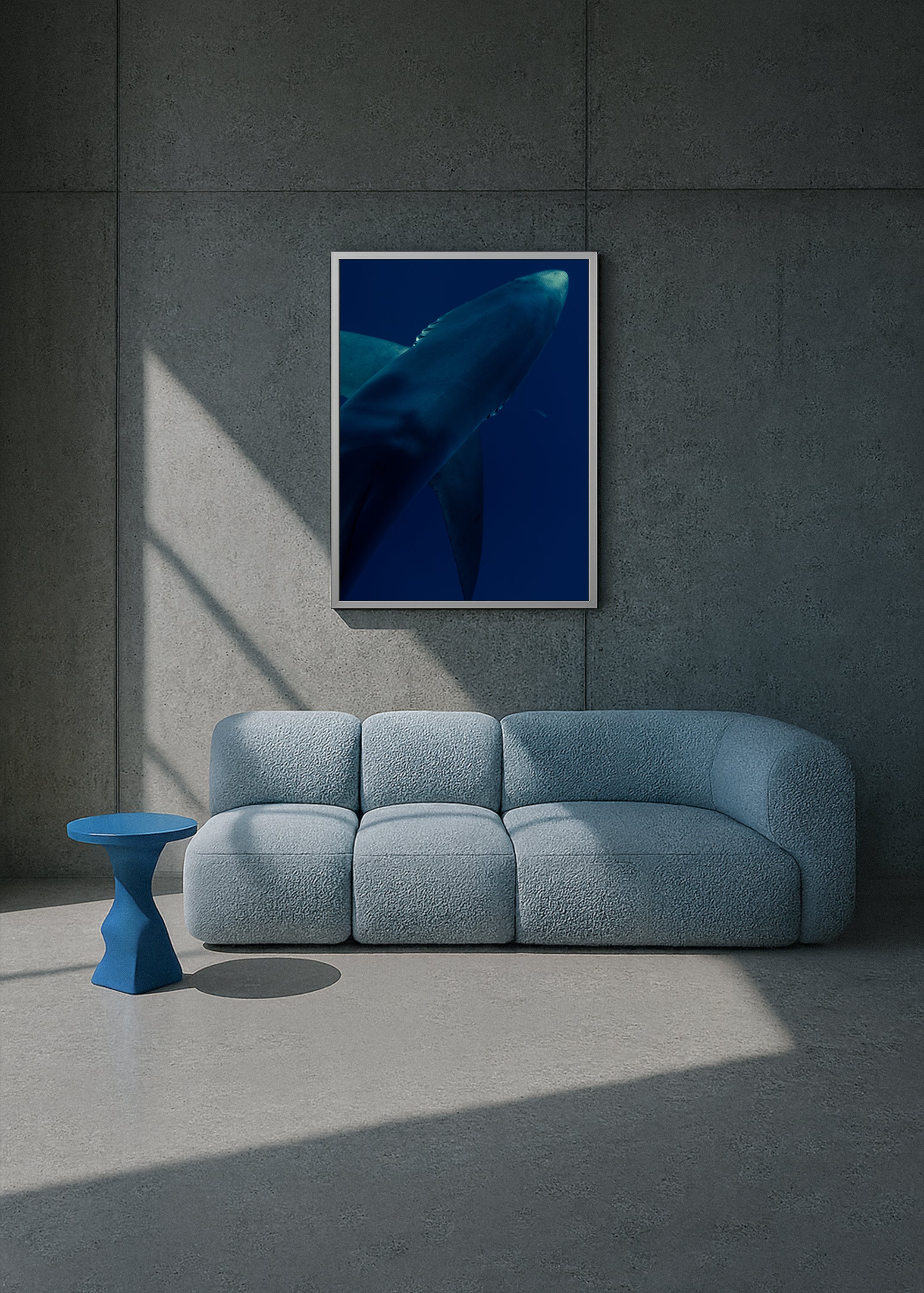Modern interior with a blue sofa, small table, and framed artwork of a whale on a gray wall. underwater blue shark portrait – shark textures II – azores 2022 – her sky visual series